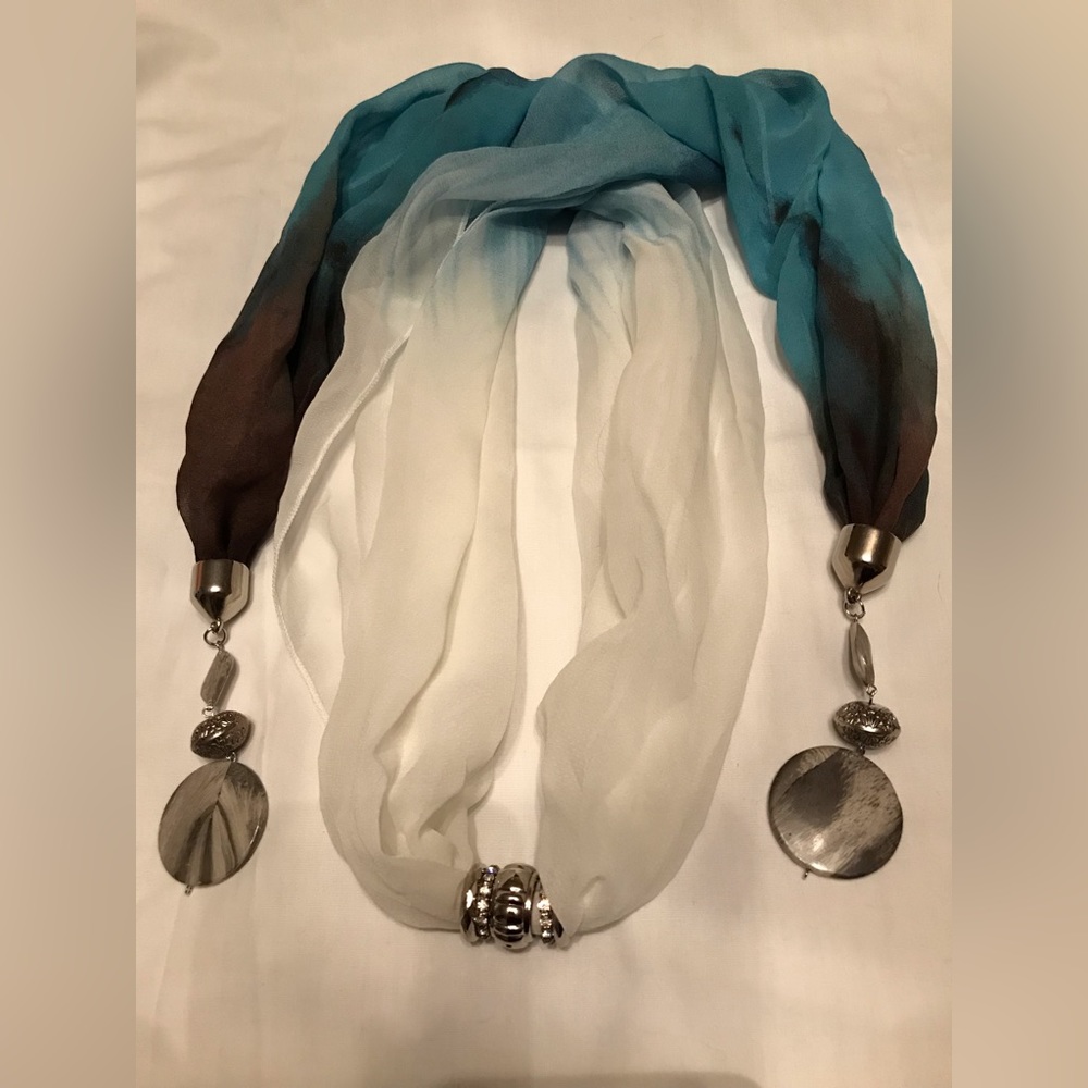 Scarf with attached jewelry